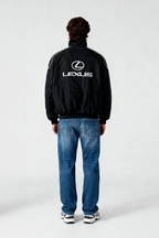 Black Lexus racing jacket with white logo and stripes, worn with jeans and sneakers from revnhaus
