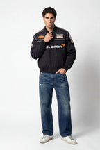 Men's black McLaren racing bomber jacket with patches, styled with jeans and sneakers from revnhaus