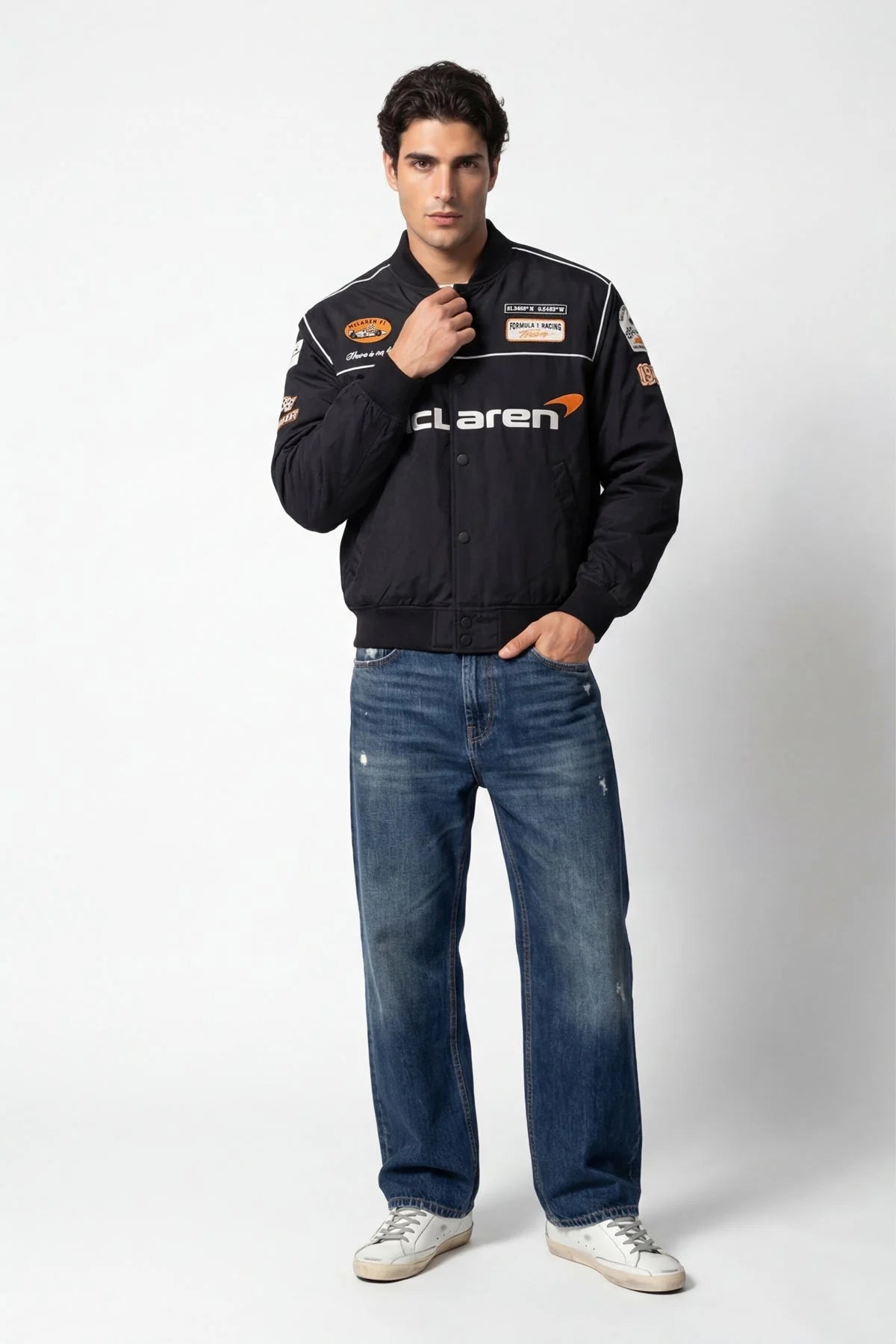Men's black McLaren racing bomber jacket with patches, styled with jeans and sneakers from revnhaus