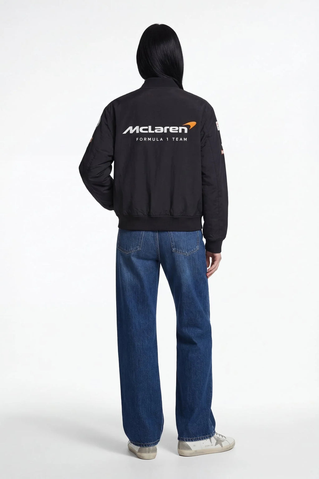 Black McLaren Formula 1 Team bomber jacket with logo, worn with blue jeans from revnhaus