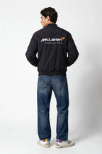 Man wearing black McLaren Formula 1 Team bomber jacket with jeans and sneakers from revnhaus