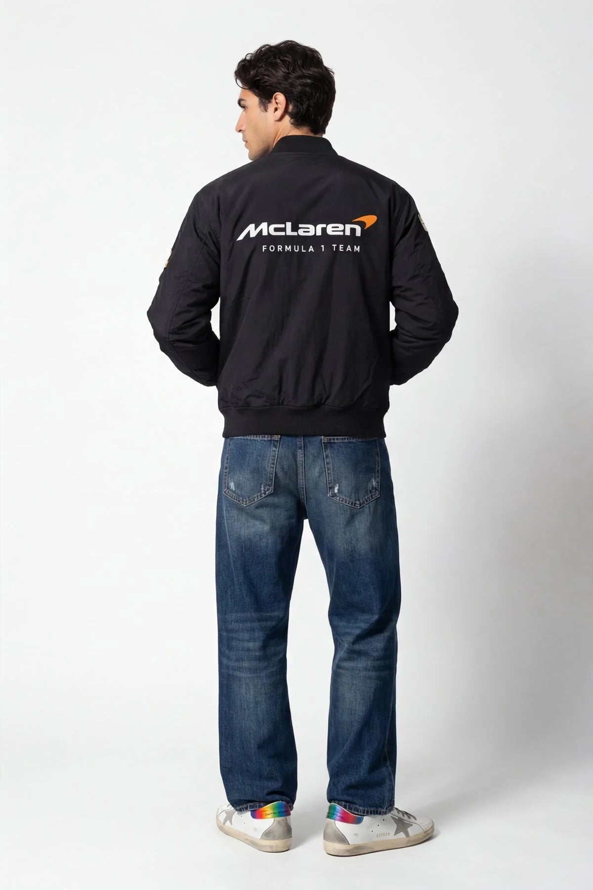 Man wearing black McLaren Formula 1 Team bomber jacket with jeans and sneakers from revnhaus