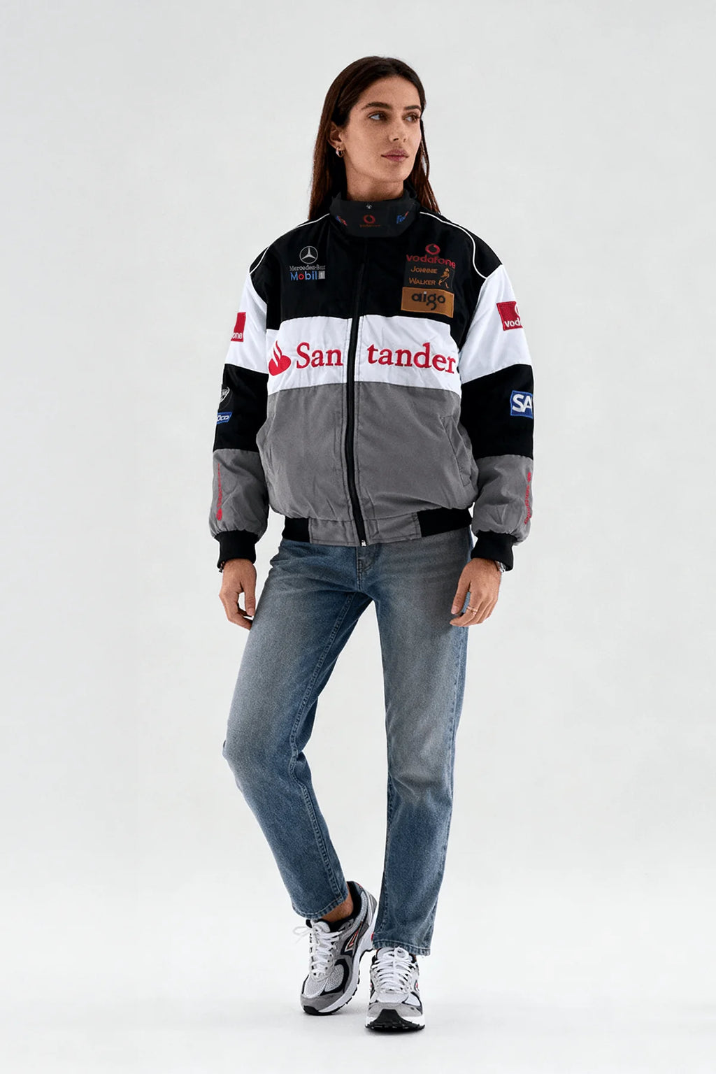 Women's racing-inspired bomber jacket with sponsor logos, paired with jeans and sneakers from revnhaus