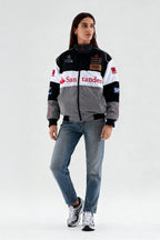 Women's racing-inspired bomber jacket with sponsor logos, paired with jeans and sneakers from revnhaus