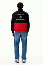 Black and red McLaren Mercedes-Benz racing jacket worn with jeans, from revnhaus