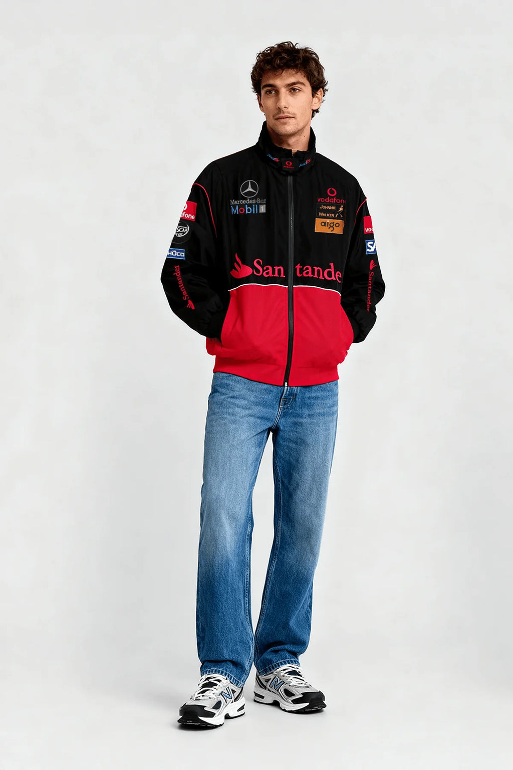 Black and red racing jacket with sponsor logos, worn with jeans and sneakers from revnhaus