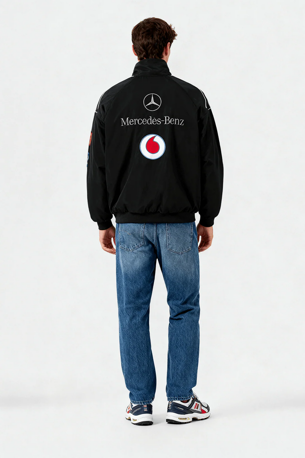 Black Mercedes-Benz Vodafone racing jacket with logos, worn with jeans and sneakers from revnhaus