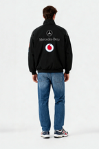 Black Mercedes-Benz Vodafone racing jacket with logos, worn with jeans and sneakers from revnhaus