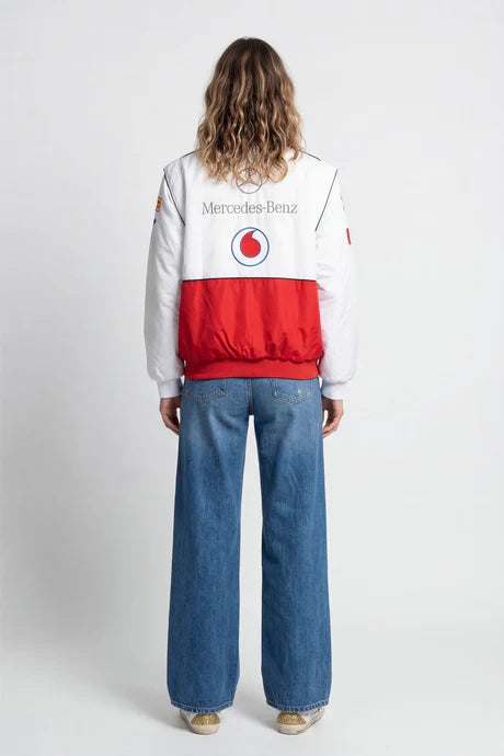 White and red racing bomber jacket with Mercedes-Benz and Vodafone logos, worn with wide-leg jeans from revnhaus