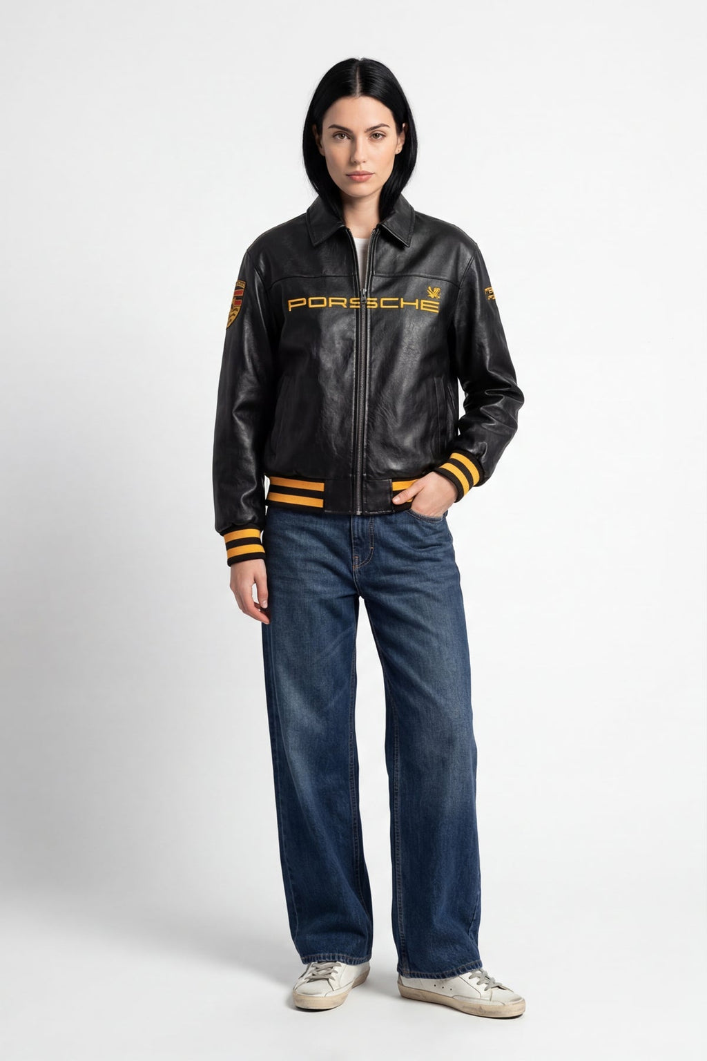 Black Porsche leather racing jacket with gold lettering and stripes, styled with jeans from revnhaus
