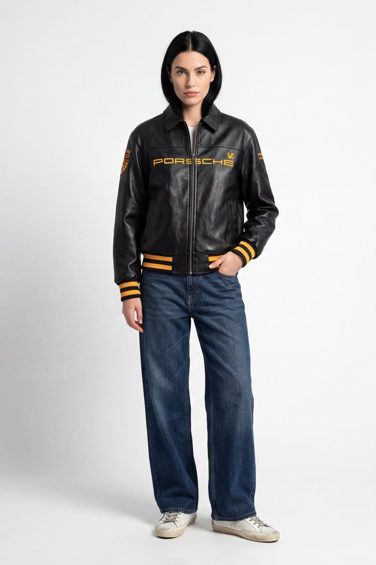 Black Porsche leather racing jacket with gold lettering and stripes, styled with jeans from revnhaus