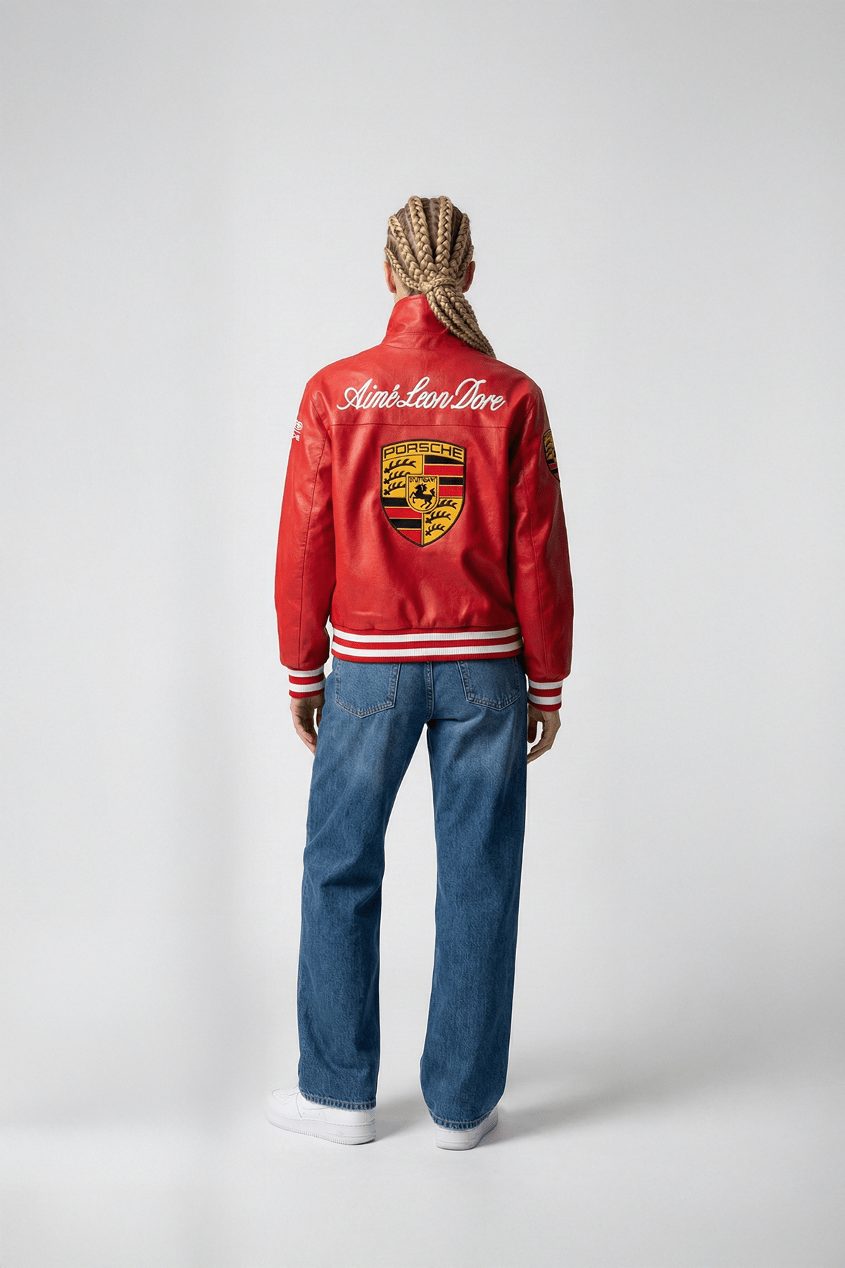 Red Porsche varsity jacket with Aime Leon Dore branding, worn with jeans from revnhaus