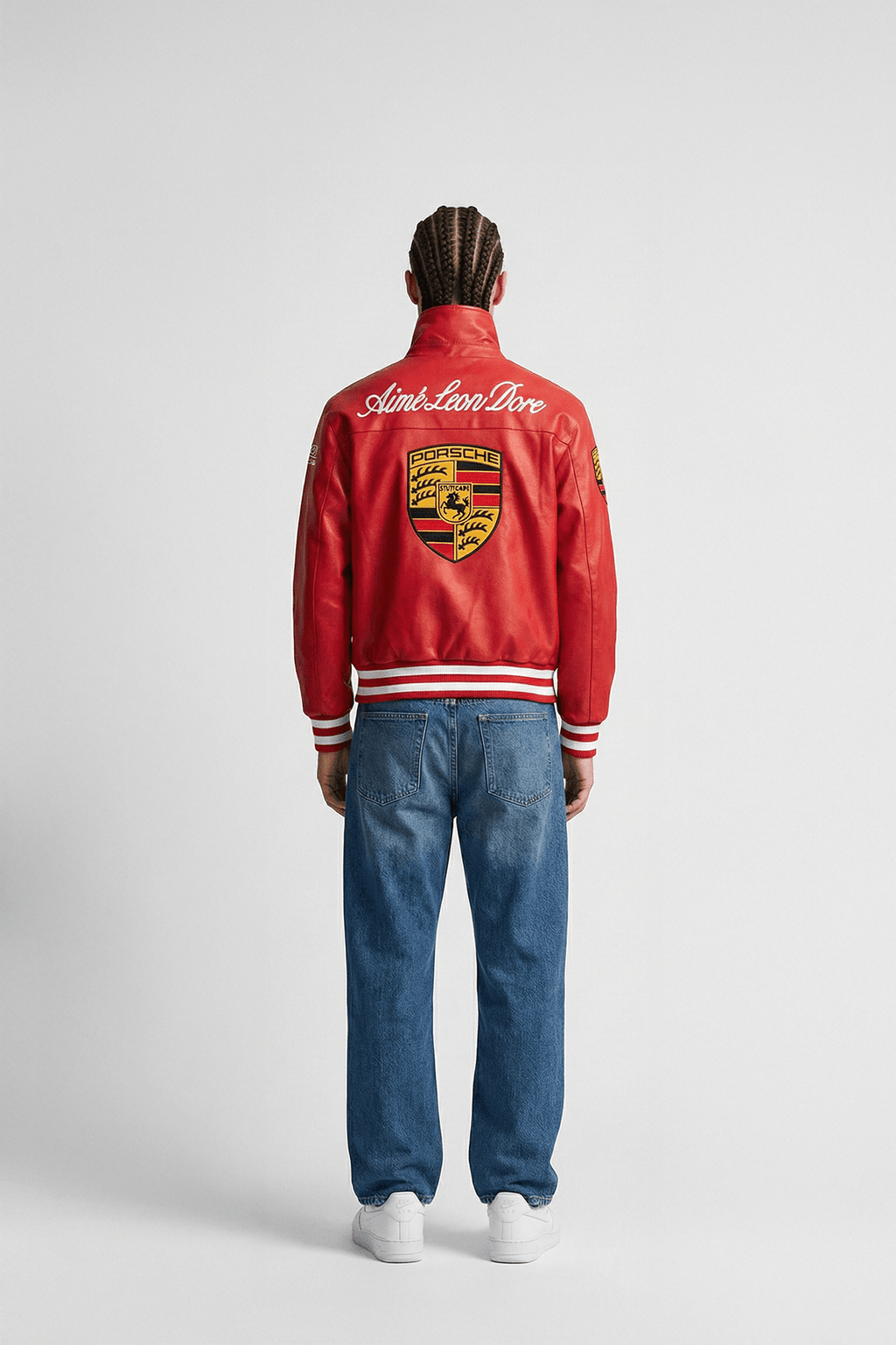 Red Porsche varsity jacket with Aime Leon Dore branding, worn with jeans from revnhaus