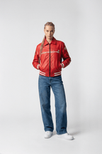 Red Porsche racing jacket with white stripes, worn with jeans and sneakers from revnhaus