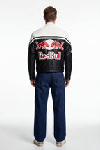 Red Bull racing leather jacket with bold logo, worn by model in jeans, from revnhaus