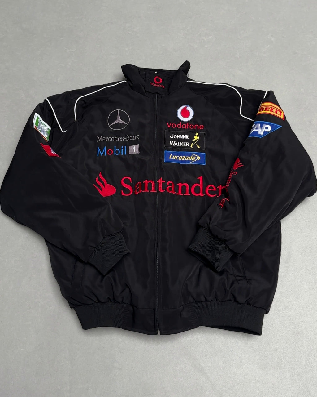 Black F1 racing jacket with Vodafone, Santander, Mercedes-Benz logos from revnhaus