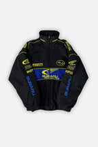 Black Subaru World Rally Team jacket with yellow and blue sponsor logos, from revnhaus