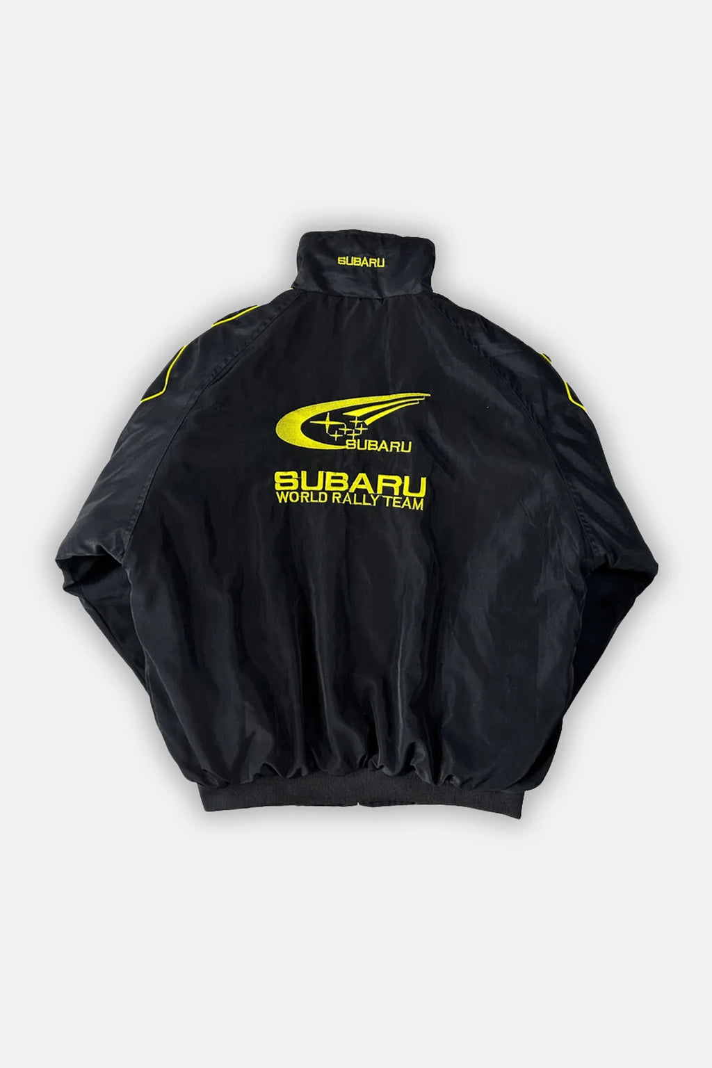 Black Subaru World Rally Team jacket with yellow logo and trim from revnhaus