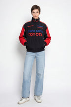 Panasonic Toyota racing jacket with red sleeves and sponsor logos, styled with jeans from revnhaus
