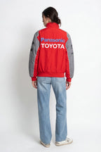 Red and gray Panasonic Toyota racing jacket with bold logo, worn with jeans from revnhaus