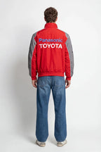 Red and gray Panasonic Toyota racing jacket worn with blue jeans from revnhaus