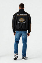 Black Harley-Davidson 100th Anniversary jacket with gold trim, worn with jeans and sneakers from revnhaus