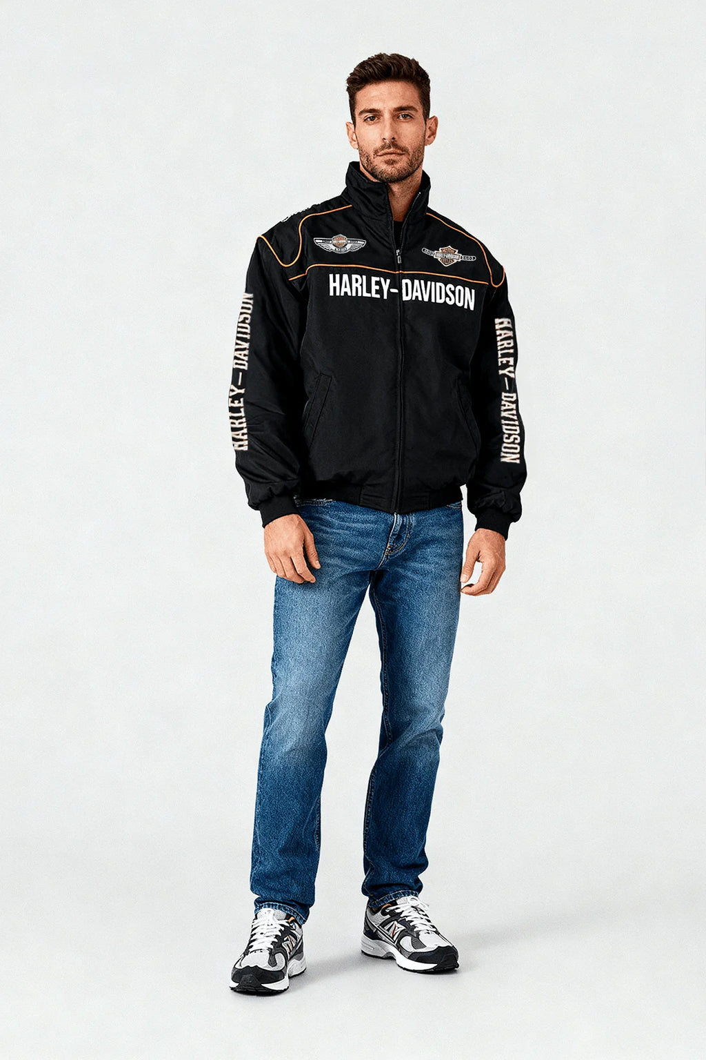 Black Harley-Davidson racing jacket with bold branding and orange trim, worn with jeans and sneakers from revnhaus