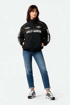 Black Harley-Davidson racing jacket with orange trim and logos, worn with jeans and sneakers from revnhaus