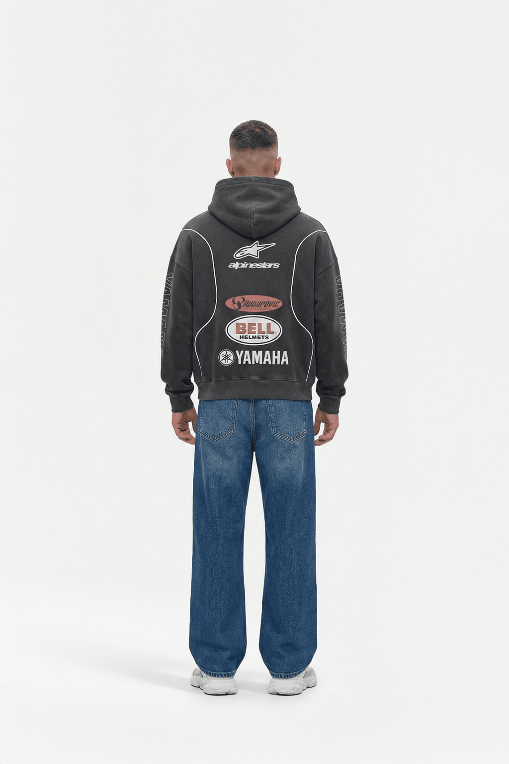 Black motorsport hoodie with Alpinestars, Bell, Yamaha logos, worn with jeans from revnhaus
