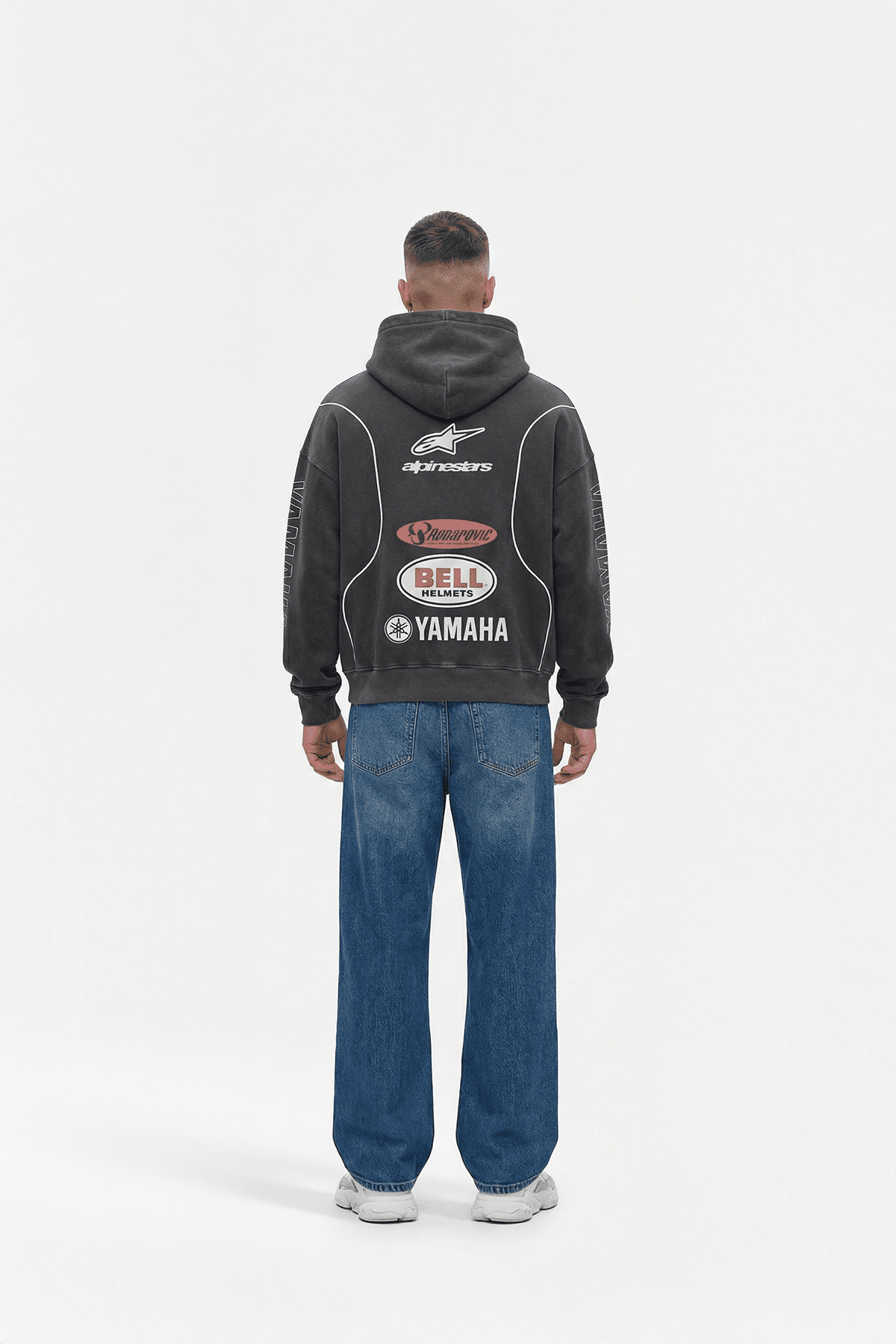 Black motorsport hoodie with Alpinestars, Bell, Yamaha logos, worn with jeans from revnhaus